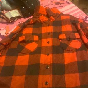 A red and black plaid button down shirt with buttons and pockets